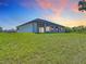 Exterior view of the backyard featuring a sprawling lawn with a covered patio and a well-manicured lawn at 10588 Kidron Ave, Englewood, FL 34224