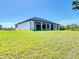 Exterior view of the backyard featuring a sprawling lawn with a covered patio and a well-manicured lawn at 10588 Kidron Ave, Englewood, FL 34224