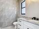 Bathroom featuring marble-look tile, a white vanity cabinet with granite countertops and sleek fixtures at 10588 Kidron Ave, Englewood, FL 34224