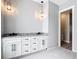 Bathroom vanity area with granite counters, double sinks, and modern pendant lighting at 10588 Kidron Ave, Englewood, FL 34224