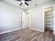 Bedroom featuring wood-look floors, modern ceiling fan and walk-in closet with shelving at 10588 Kidron Ave, Englewood, FL 34224