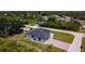 Aerial view of a modern home featuring a long driveway and a well-maintained lawn and landscape at 10588 Kidron Ave, Englewood, FL 34224