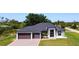 Beautifully landscaped home with a modern design, featuring a three-car garage and a well-manicured lawn at 10588 Kidron Ave, Englewood, FL 34224