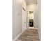 Hallway leading to a laundry room with a modern front load washing machine and white storage cabinets at 10588 Kidron Ave, Englewood, FL 34224