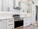 Modern kitchen showcasing stainless steel appliances, stylish cabinets, and granite countertops with a designer range hood at 10588 Kidron Ave, Englewood, FL 34224
