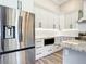 Sleek kitchen featuring stainless steel appliances, white cabinets, and granite countertops with stylish backsplash at 10588 Kidron Ave, Englewood, FL 34224