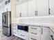 Kitchen features white cabinets, granite countertops, stainless refrigerator, and modern backsplash at 10588 Kidron Ave, Englewood, FL 34224