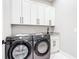 Well-organized laundry room boasts granite countertop, white cabinets, and modern Samsung washer/dryer units at 10588 Kidron Ave, Englewood, FL 34224