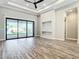 Bright living room with sliding glass doors, modern light fixtures, and sleek wood flooring at 10588 Kidron Ave, Englewood, FL 34224