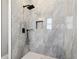 Modern shower featuring sleek black fixtures and stylish gray tiled walls with a convenient shelf at 10588 Kidron Ave, Englewood, FL 34224