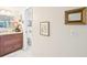 A view of the stylish bathroom vanity and wall decor, with a glimpse into the toilet at 1170 Bird Bay Way # 206, Venice, FL 34285