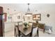 A stylish dining room offers a modern chandelier, seating for four, and an adjoining kitchen at 1170 Bird Bay Way # 206, Venice, FL 34285