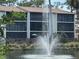 Exterior view of condo building with balconies overlooking water feature, landscaping, and inviting outdoor living spaces at 1170 Bird Bay Way # 206, Venice, FL 34285