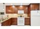 Bright kitchen features wooden cabinets, stone counters and white appliances at 1170 Bird Bay Way # 206, Venice, FL 34285