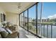 Enclosed lanai featuring comfortable seating and views of the serene lake, creating a perfect relaxation spot at 1170 Bird Bay Way # 206, Venice, FL 34285