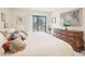 Cozy main bedroom offering tile floors, neutral decor, and sliding glass door with a balcony view at 1170 Bird Bay Way # 206, Venice, FL 34285