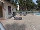 Community pool area with chaise lounges, tables and umbrellas, a shower and posted rules at 1170 Bird Bay Way # 206, Venice, FL 34285