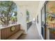 Exterior hallway with bench and railing leading to front door of unit at 1170 Bird Bay Way # 206, Venice, FL 34285