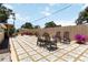 Seating area on a beautiful stone-paved backyard patio with a privacy fence and nice landscaping at 1212 Princeton Ave, Bradenton, FL 34207