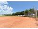 Scenic baseball field with well-maintained dirt infield, surrounded by trees under a clear blue sky at 1212 Princeton Ave, Bradenton, FL 34207
