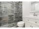 Bathroom with stand-up shower with decorative tile surround, rainfall shower head, and glass door at 1212 Princeton Ave, Bradenton, FL 34207