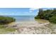 A tranquil beach area with shallow water, surrounded by lush greenery creating a serene atmosphere at 1212 Princeton Ave, Bradenton, FL 34207