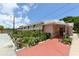 Exterior view of the building with a ramp entrance, flowers, and adjacent parking at 1212 Princeton Ave, Bradenton, FL 34207