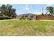 Beautiful one story home with landscaping, solar panels, a vibrant blue front door and a wooden fence at 1212 Princeton Ave, Bradenton, FL 34207