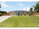 Charming single-story home with a well-manicured lawn, blue front door, solar panels, and a wooden fence at 1212 Princeton Ave, Bradenton, FL 34207