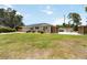 Single story home with green lawn, landscaping, blue door, privacy fence, and solar panels at 1212 Princeton Ave, Bradenton, FL 34207