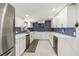 Bright, renovated kitchen features white cabinetry, quartz countertops, and stylish blue backsplash at 1212 Princeton Ave, Bradenton, FL 34207