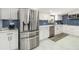 Modern kitchen boasts stainless steel appliances, white cabinets, and eye-catching blue backsplash at 1212 Princeton Ave, Bradenton, FL 34207
