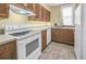 Traditional kitchen featuring wood cabinets, white appliances, and tile flooring at 1221 N Palm Ave # 303, Sarasota, FL 34236