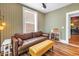 Stylish living room featuring patterned wallpaper, a brown leather sofa, and a bright yellow ottoman at 1221 N Palm Ave # 303, Sarasota, FL 34236