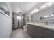 Modern bathroom featuring dual sinks, a spacious shower, and gray tile flooring at 12214 Hernando Rd, North Port, FL 34287