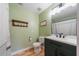 Bathroom featuring a green vanity, toilet, shower, and wooden floors, blending functionality with a refreshing aesthetic at 12214 Hernando Rd, North Port, FL 34287