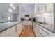 Bright kitchen with wooden floors, white cabinets, modern appliances, and gray countertops at 12214 Hernando Rd, North Port, FL 34287