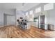 Modern kitchen featuring white cabinets, stainless steel appliances, a kitchen island with bar seating, and wood floors at 12214 Hernando Rd, North Port, FL 34287