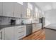 Bright kitchen with wooden floors, white cabinets, modern appliances, and gray countertops at 12214 Hernando Rd, North Port, FL 34287