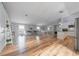 Open floor plan featuring a large gray sectional, wood floors, and a modern kitchen with an island and stainless steel appliances at 12214 Hernando Rd, North Port, FL 34287