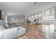 Spacious open concept living area with wood floors, a gray sectional, and a modern kitchen featuring an island at 12214 Hernando Rd, North Port, FL 34287