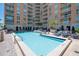 Resort style pool area with lounge chairs, palm trees and elegant building in the background at 1350 Main St # 1703, Sarasota, FL 34236