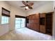 Bedroom with built-in shelving, a ceiling fan and sliding glass doors to a patio at 13809 18Th E Pl, Bradenton, FL 34212