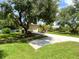 Long driveway leading to a two-car garage, surrounded by manicured lawn and mature trees at 13809 18Th E Pl, Bradenton, FL 34212
