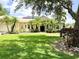 Inviting home exterior featuring a well-kept lawn, mature trees, and a welcoming entrance at 13809 18Th E Pl, Bradenton, FL 34212