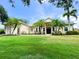 Charming single-story home featuring a well-manicured lawn, palm trees, and welcoming front entrance at 13809 18Th E Pl, Bradenton, FL 34212