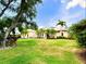 Well-maintained front yard with lush green grass, palm trees, and charming landscaping at 13809 18Th E Pl, Bradenton, FL 34212