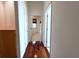 Hallway with hardwood floors leading to carpeted bedrooms and white doors at 13809 18Th E Pl, Bradenton, FL 34212