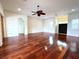 Spacious living room with hardwood floors, arched entryway, ceiling fan, and double door entrance at 13809 18Th E Pl, Bradenton, FL 34212
