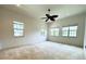 Spacious main bedroom with a ceiling fan, multiple windows, and neutral carpet at 13809 18Th E Pl, Bradenton, FL 34212
